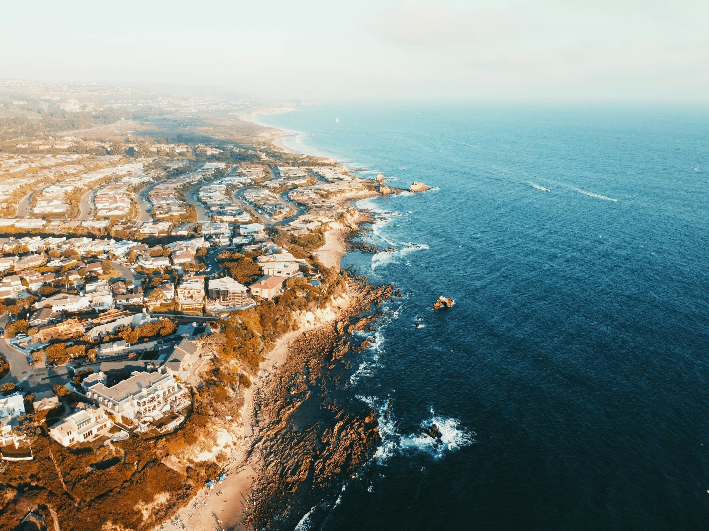 Aerial view of an Orange County coastal neighborhood running down to the shoreline